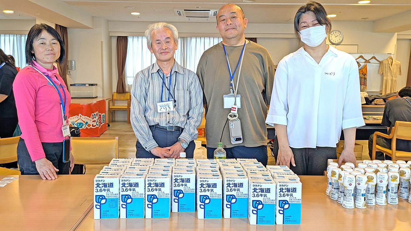 フィード・ワンから食・支援ネットに寄付されたLL牛乳。左から2人目が栗城昭司理事長