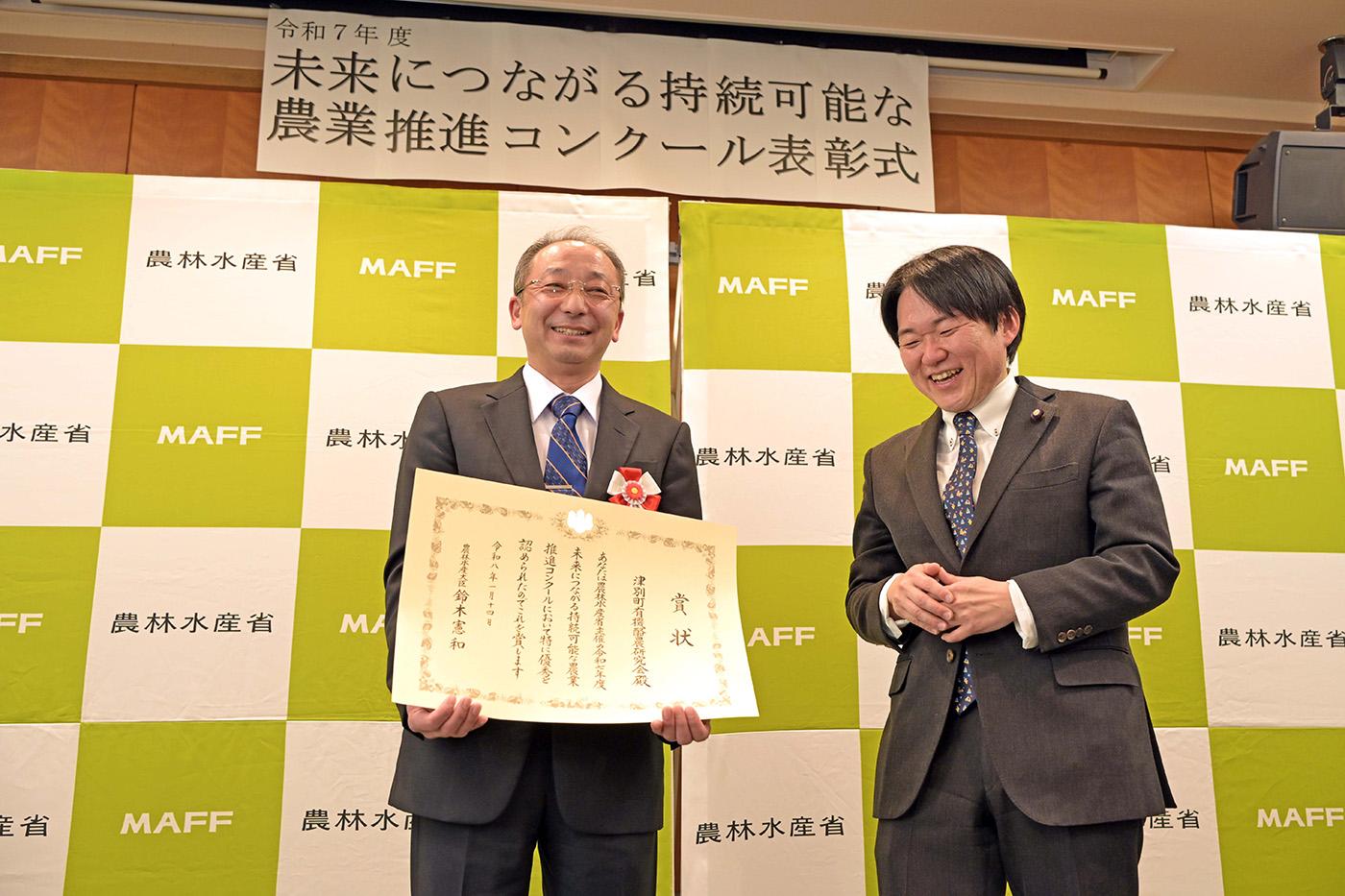 表彰状を手にする石川賢一会長（左）と山下雄平副大臣