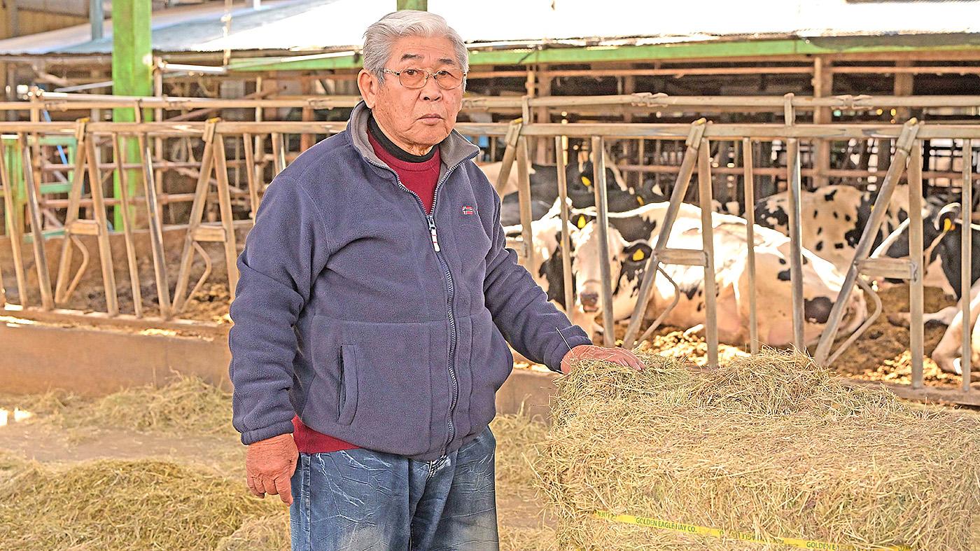 輸入粗飼料を手にする埼酪協の髙田茂組合長