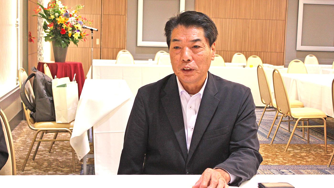 記者の質問に答える高橋秀行会長